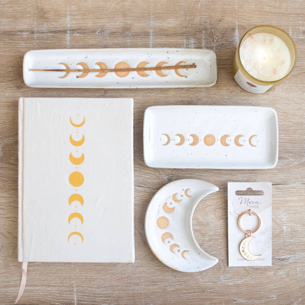 A beautiful stoneware incense holder featuring a moon phase design with a wax resist finish, giving it a handmade feel.