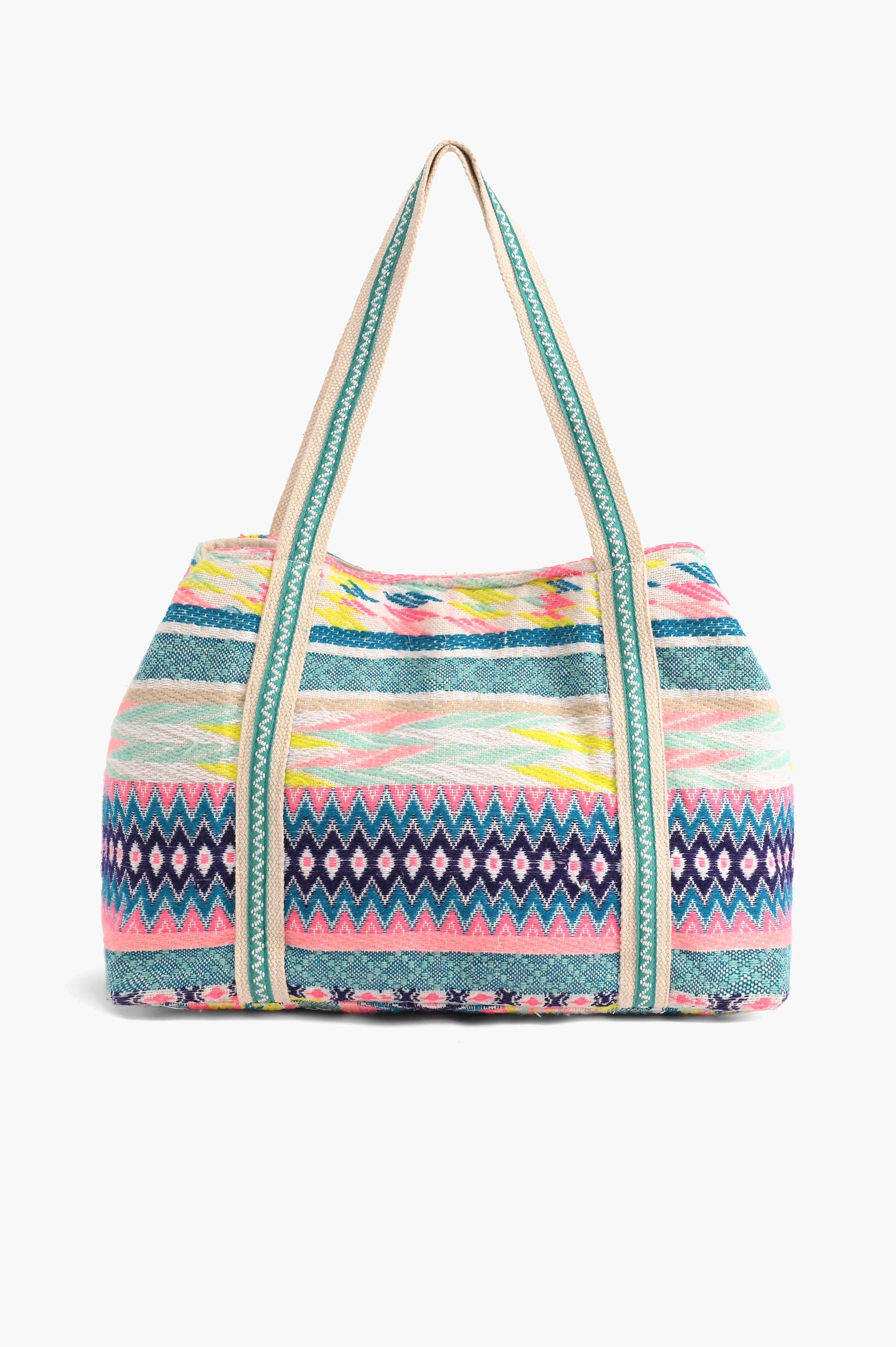 Multicolor embroidered crossbody bag with abstract beading, patterned sides, pom-pom trim, and detachable strap.