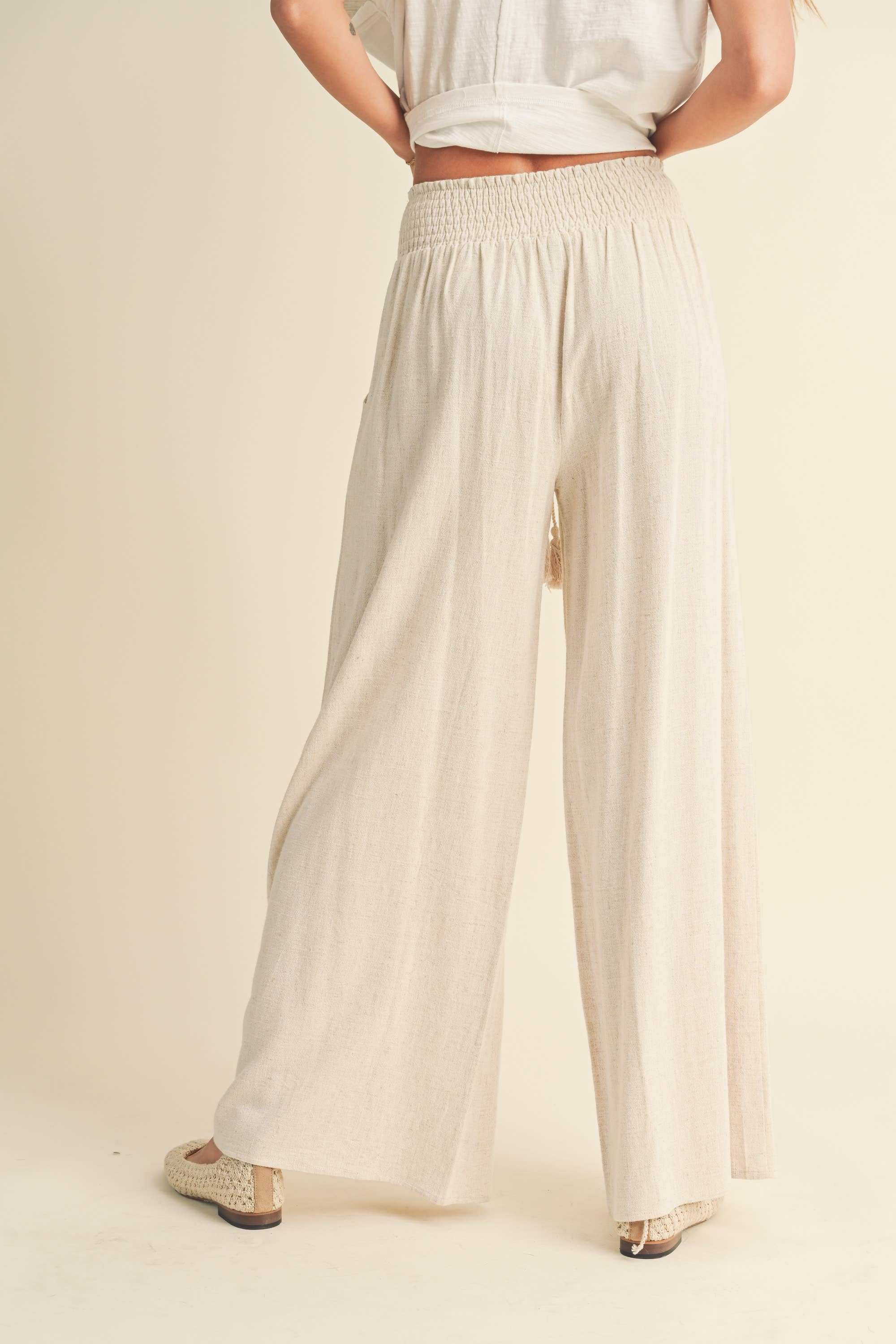 Wide-leg cotton-linen pants with smocked waistband and tassel drawstring