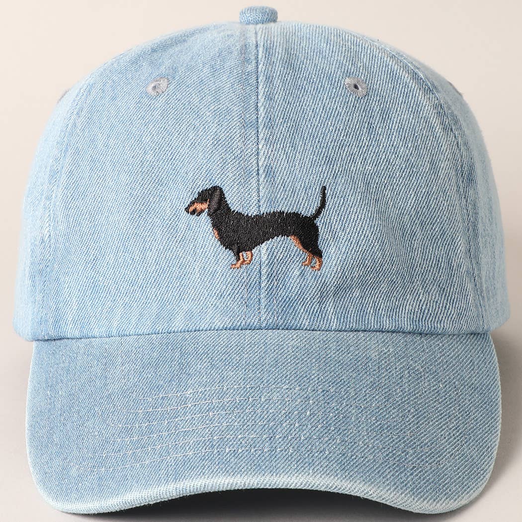 Light blue denim cap with embroidered dachshund on a beige background
