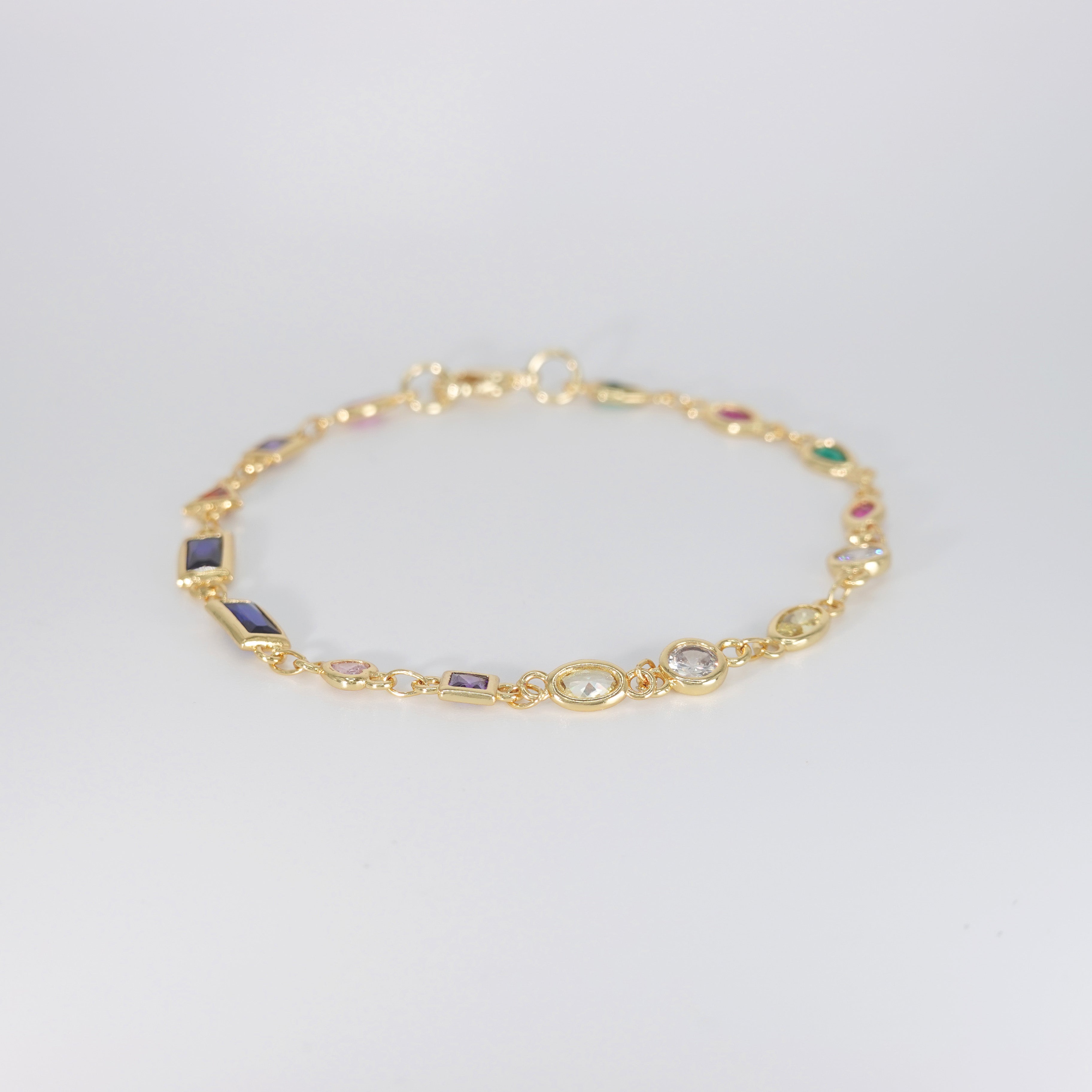Blossom Bracelet: Gold chain bracelet with colorful gemstones cascading down.