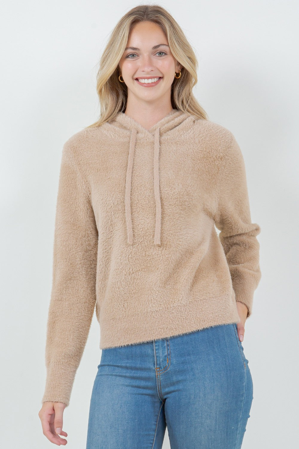 Woman wearing a beige ultra-soft hoodie with a drawstring hood.