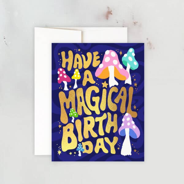 Birthday card with gold foil text reading “Have a Magical Birthday” surrounded by colorful mushrooms and stars on a dark background.