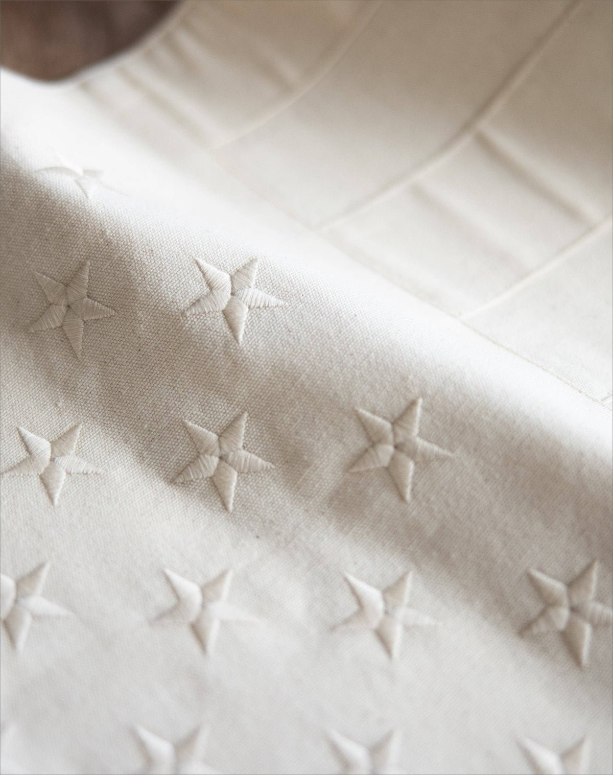 Close-up of a textured white fabric with embossed star patterns