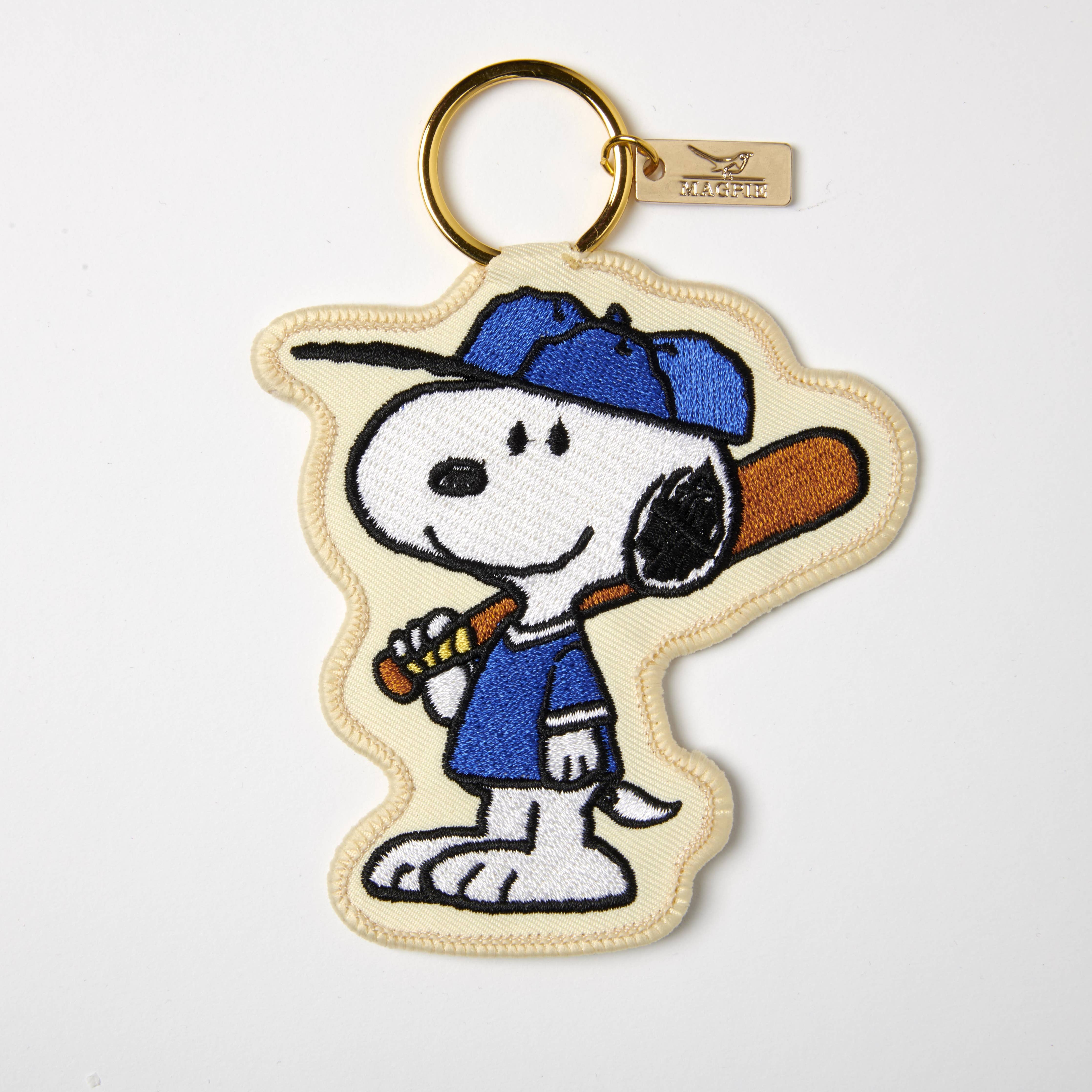 Embroidered Snoopy keychain wearing a blue baseball cap and jersey, holding a bat.