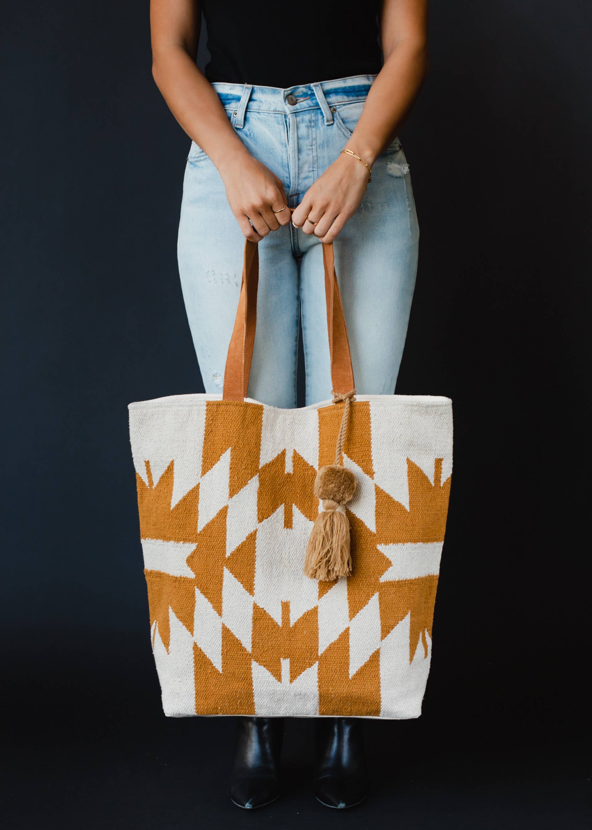 Large mustard and ivory woven tote bag with geometric pattern, leather handles, and a tassel accent