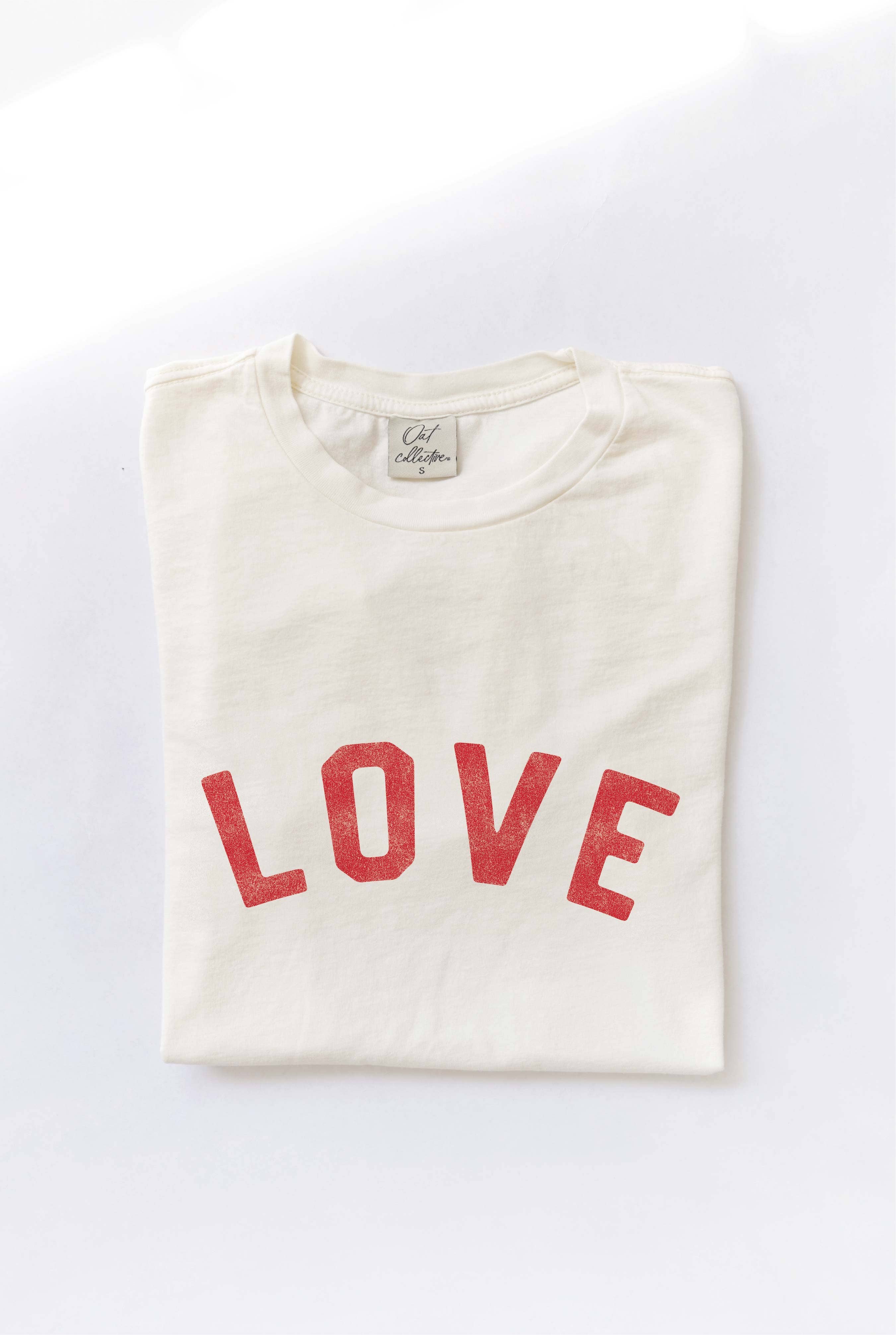 Ivory "LOVE" graphic t-shirt with bold red vintage-style lettering, made from soft cotton for a relaxed and comfortable fit.