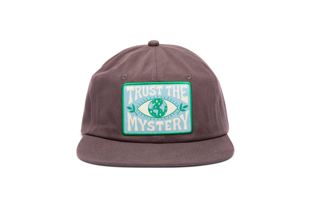 Trust The Mystery Hat: Classic baseball cap with embroidered "Trust The Mystery" slogan, epitome of confidence and style.