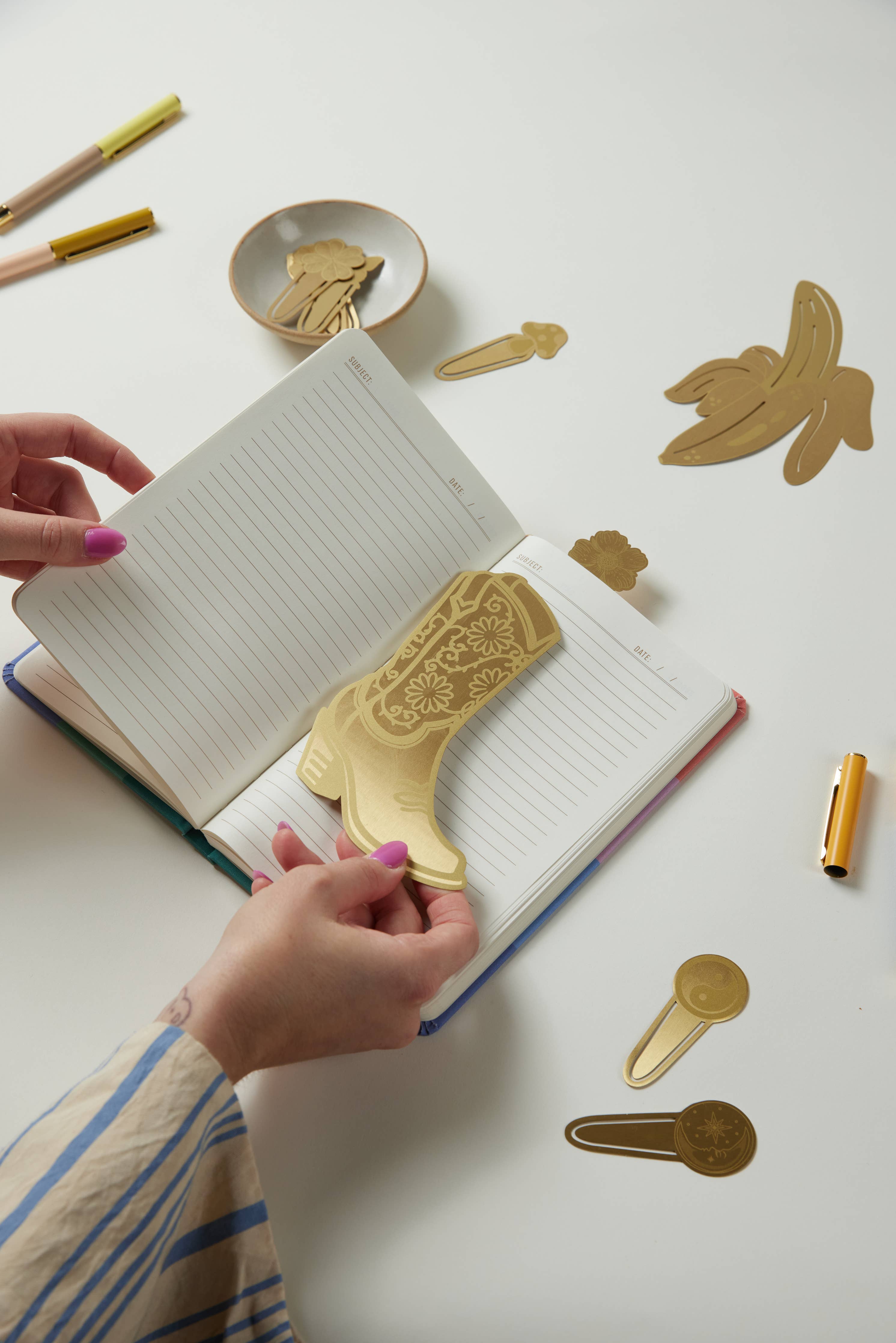 "Celestial" metal page tabs featuring a sun and moon design in brass on a white background.