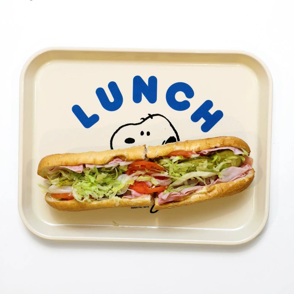 Cream-colored lunch tray featuring Snoopy holding a large sandwich, with the word “LUNCH” in bold blue letters above.