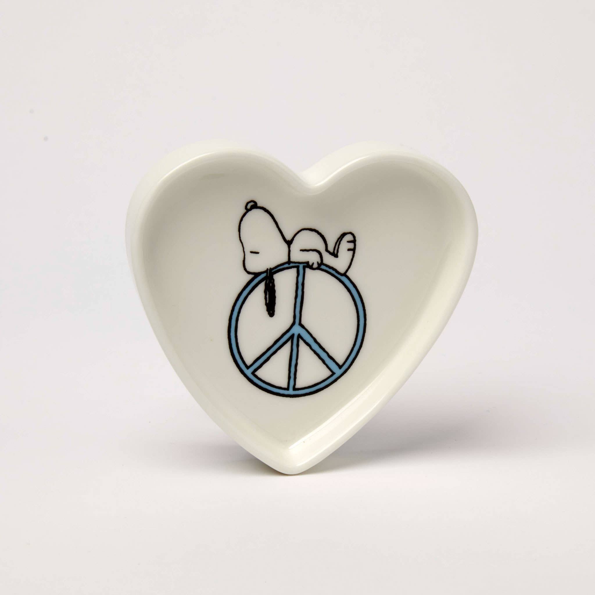 Heart-shaped trinket dish with Snoopy resting on a blue peace sign.