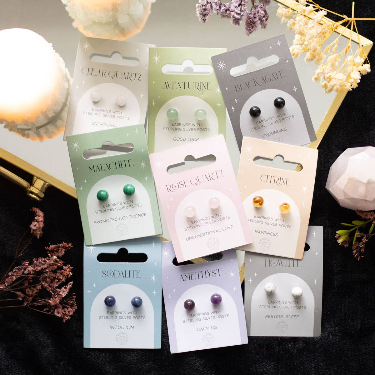 Howlite crystal stud earrings on a matching backing card held by a hand with black nail polish.