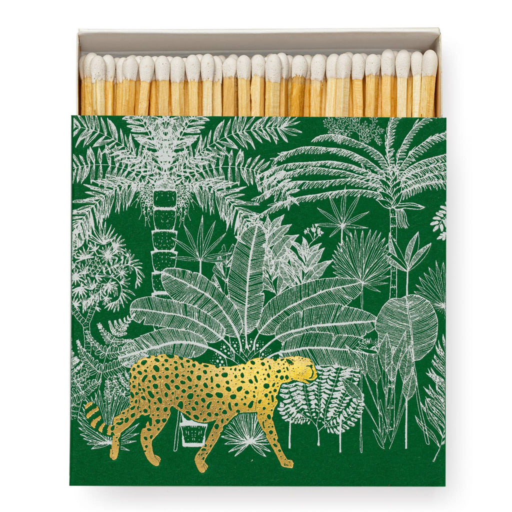 A square matchbox adorned with a cheetah amidst lush jungle foliage.