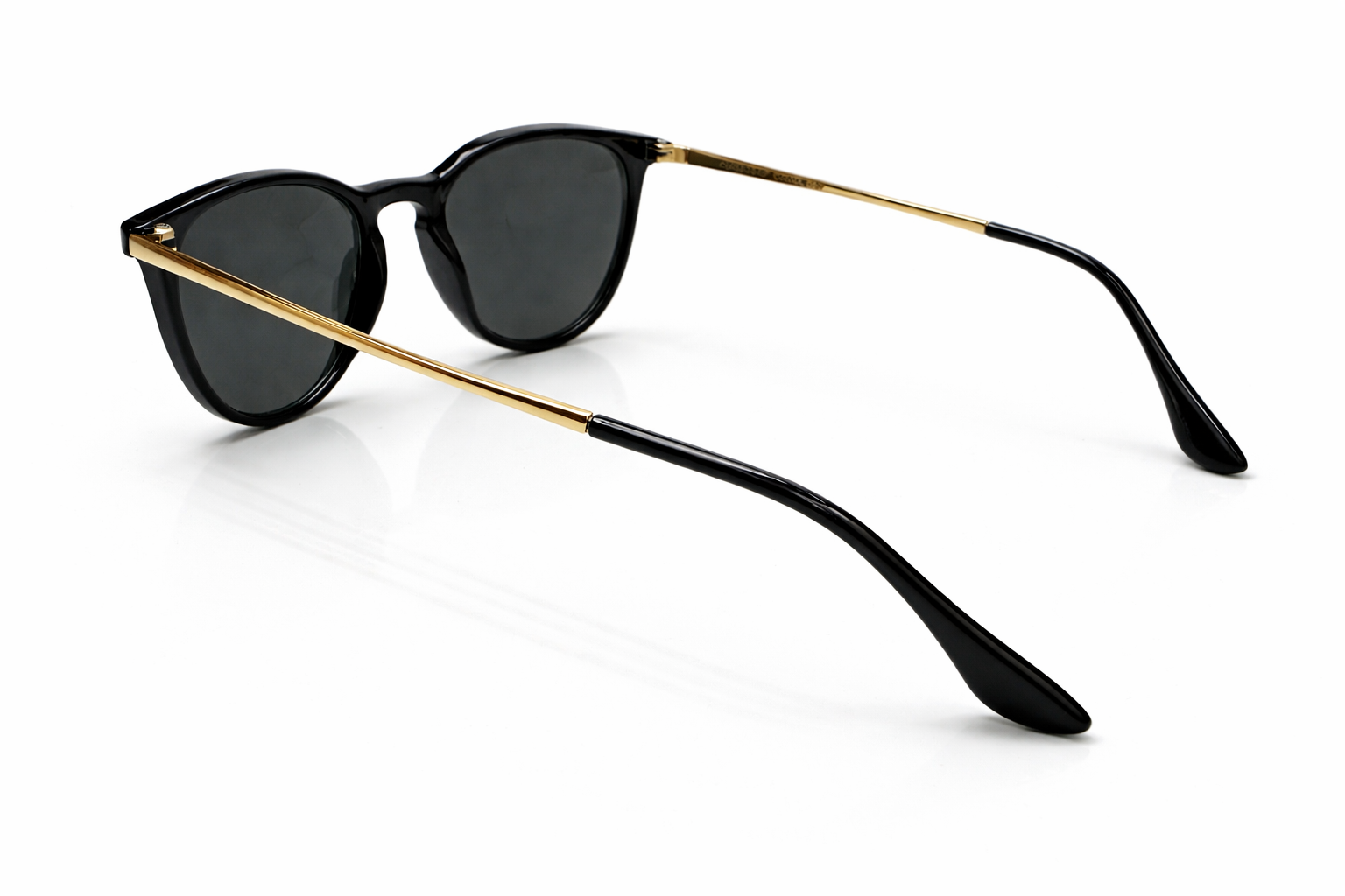 Black sunglasses with gold frames on a white background