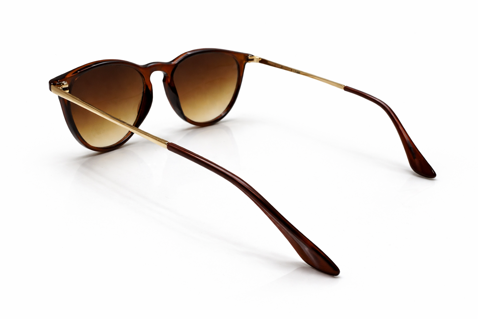 Brown sunglasses with gold frame on a white background