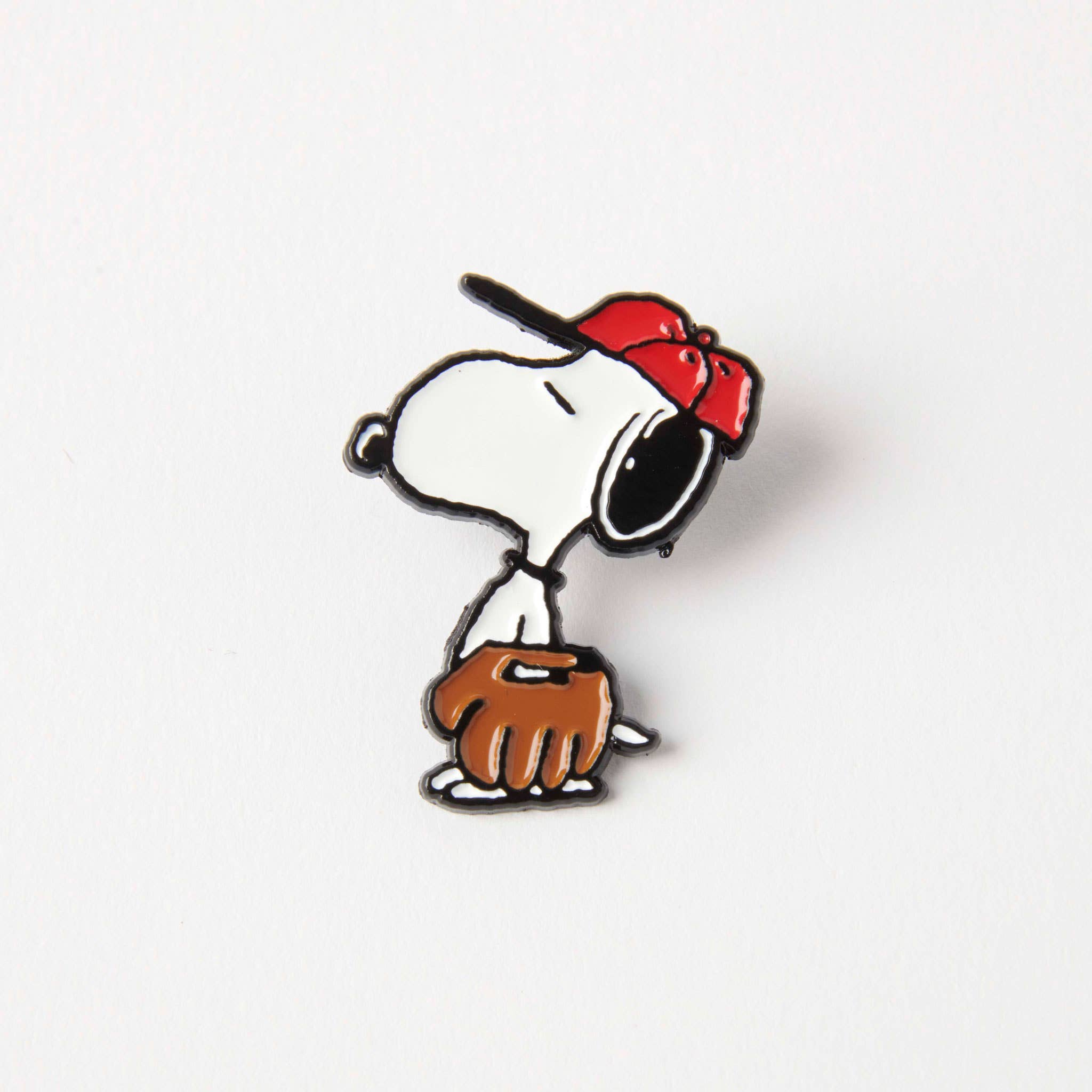 Enamel pin of Snoopy wearing a red cap and holding a baseball glove, ideal for Peanuts and baseball enthusiasts.