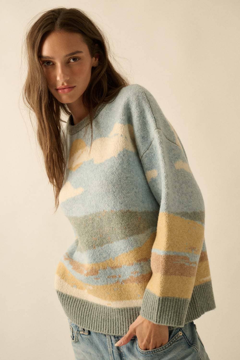 Woman wearing a colorful striped sweater against a plain background