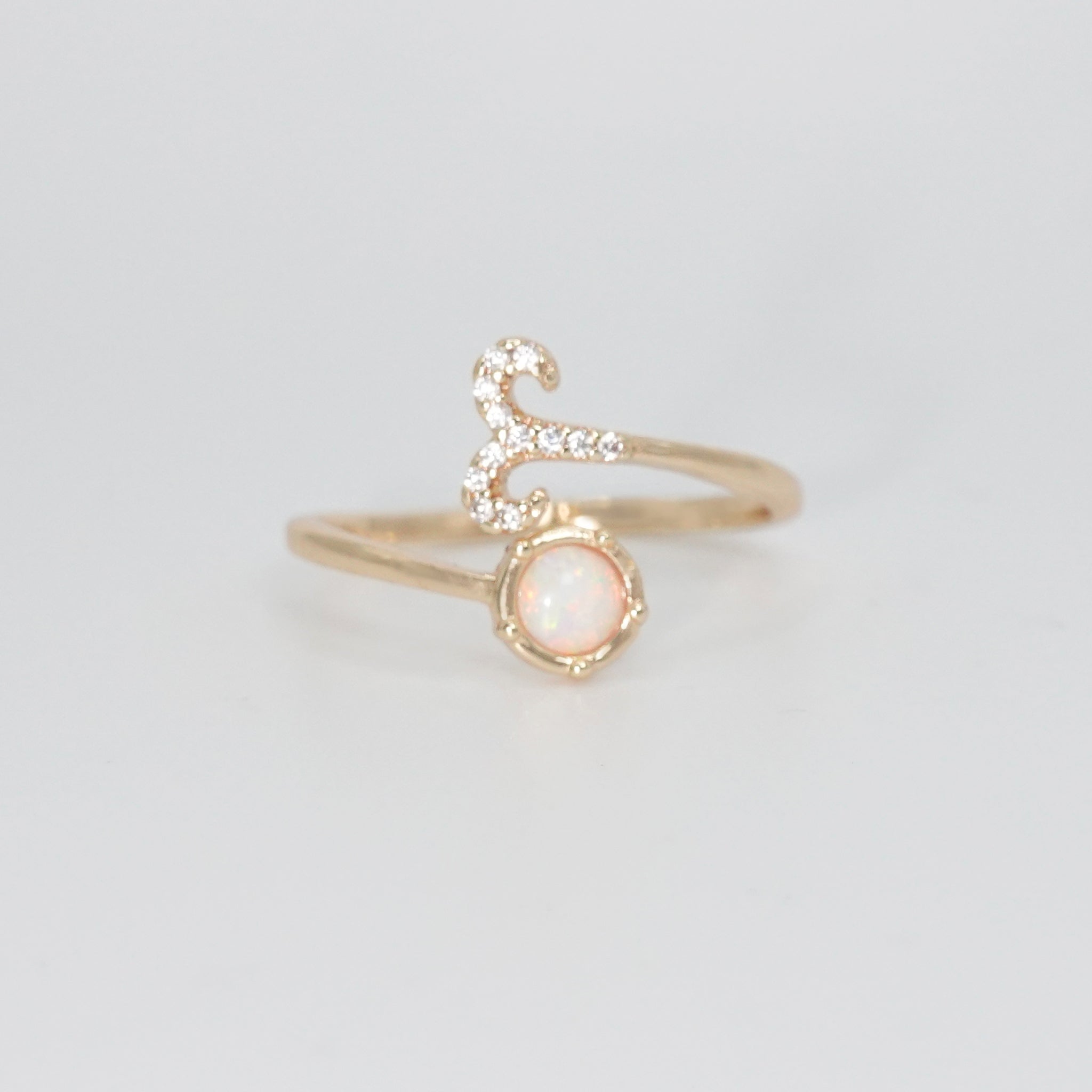 Aries Ring: Ram symbol with shimmering stones surrounding an opal, embodying fiery spirit.