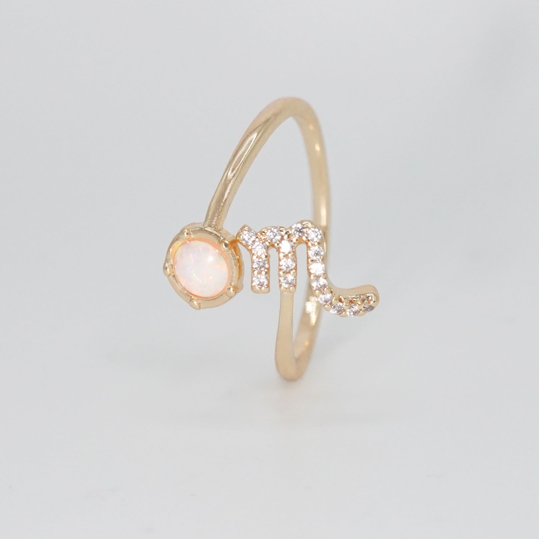 Scorpio Ring: Scorpion symbol with shimmering stones surrounding an opal, epitome of intensity.