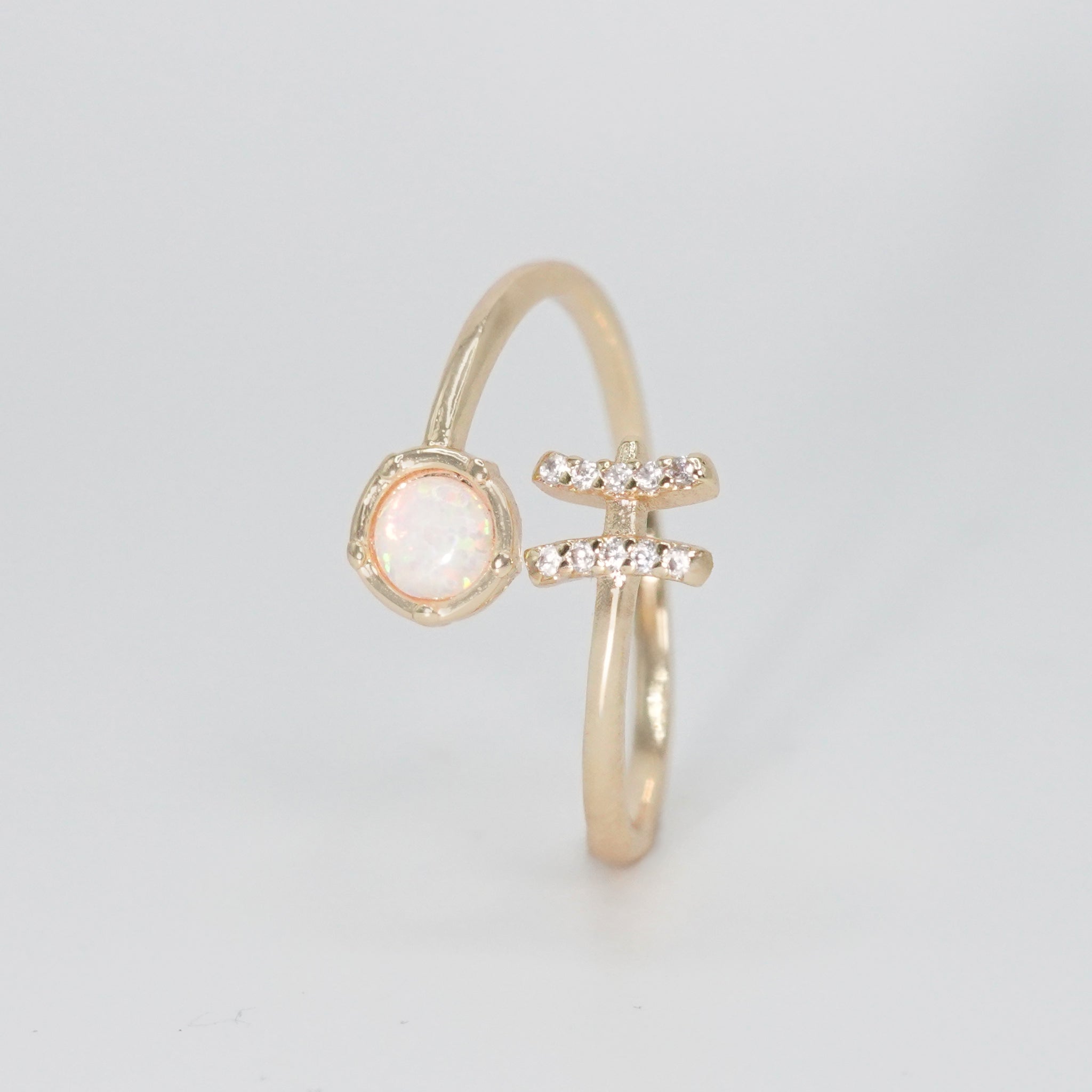 Pisces Ring: Fish symbol with shimmering stones surrounding an opal, epitome of creativity.