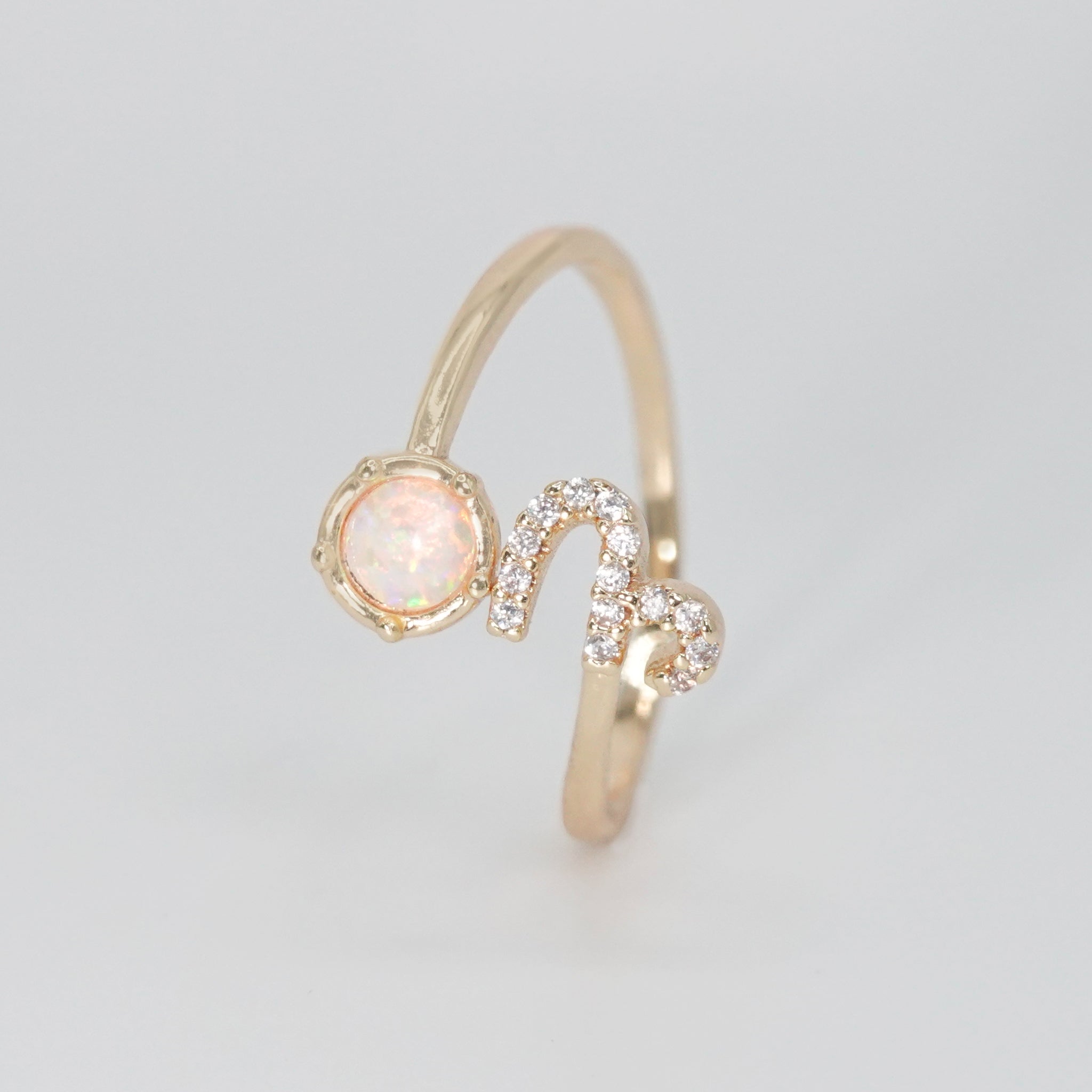 Capricorn Ring: Goat symbol with shimmering stones surrounding an opal, epitome of ambition.