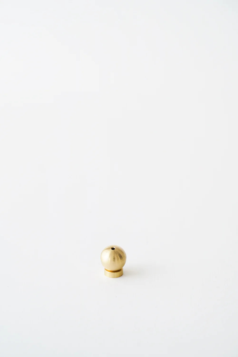 A modern Sphere Incense Holder placed on a minimalist backdrop, ideal for holding incense sticks in a stylish and secure manner.