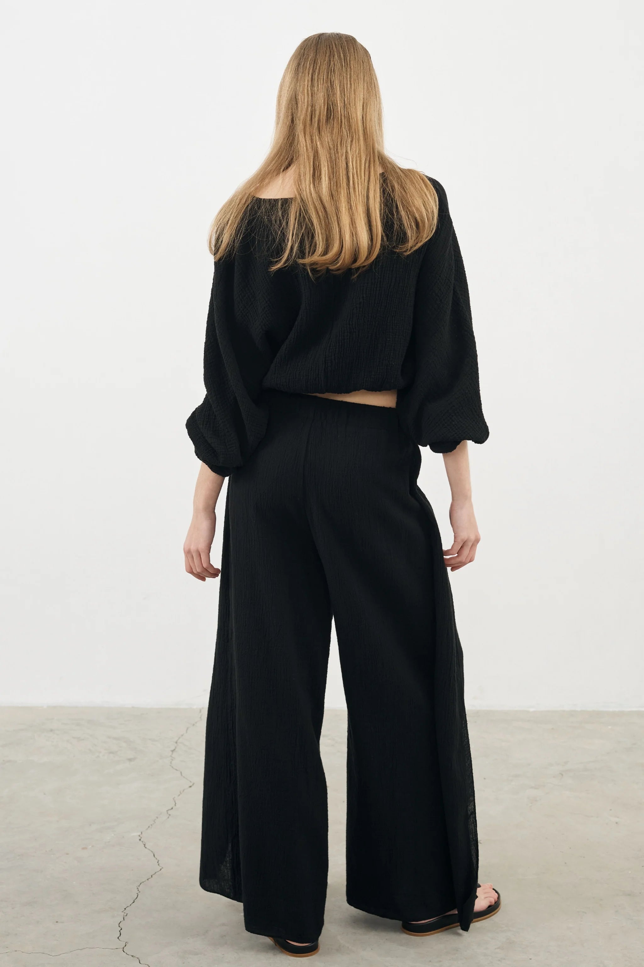 Siena Top displayed on a hanger, showcasing its wide sleeves and the unique V-shaped front drape with a hidden optional closure.