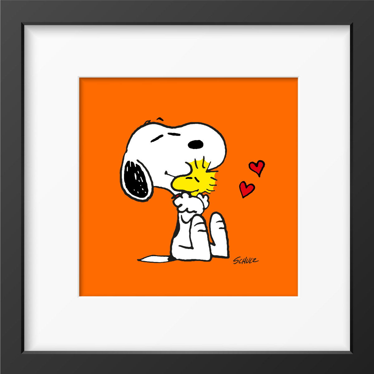 Framed artwork of Snoopy hugging Woodstock with red hearts, set against a bright orange background and framed in black.