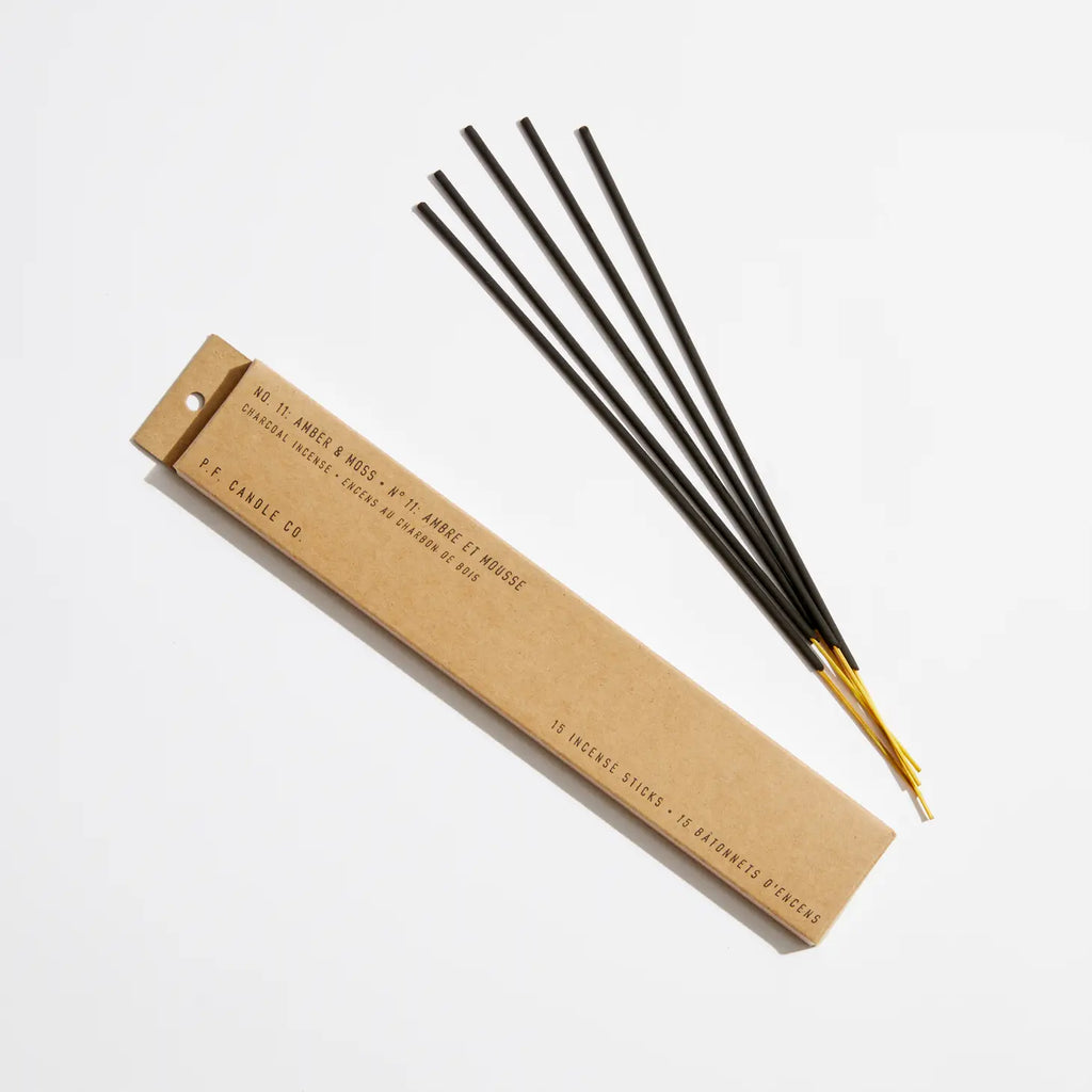 Elegant Amber & Moss Incense sticks meticulously arranged in a stylish holder, beautifully poised against a calming background.
