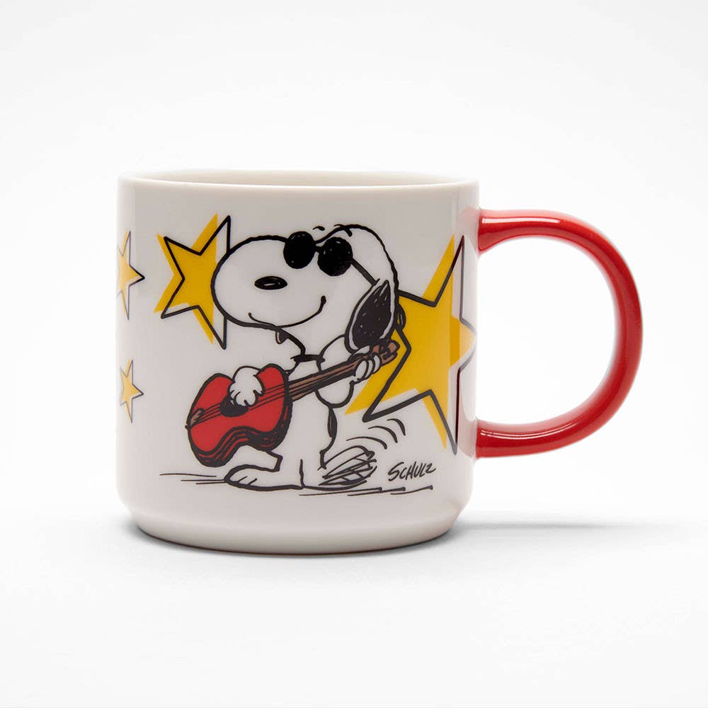 White ceramic mug with a red handle featuring a cool character playing a guitar, surrounded by yellow stars, with "Rock Star" printed on the back.