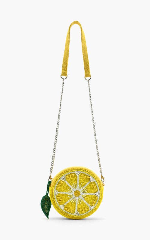Round beaded lemon slice crossbody bag with silver chain strap and green leaf charm accent.