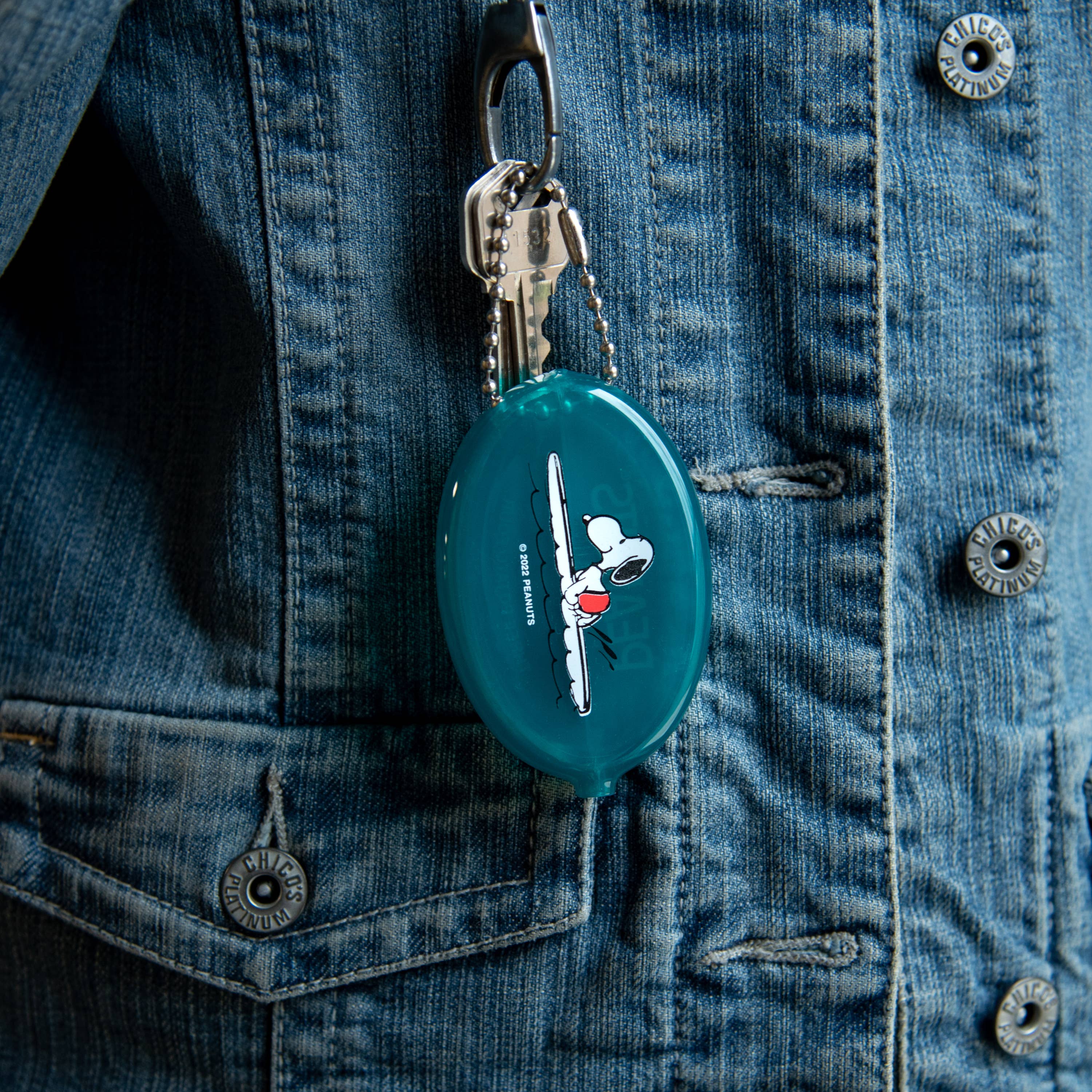 Peanuts® - Snoopy Surf Coin Pouch in teal with an illustration of Snoopy surfing on a wave, featuring a secure snap closure and attached ball chain.