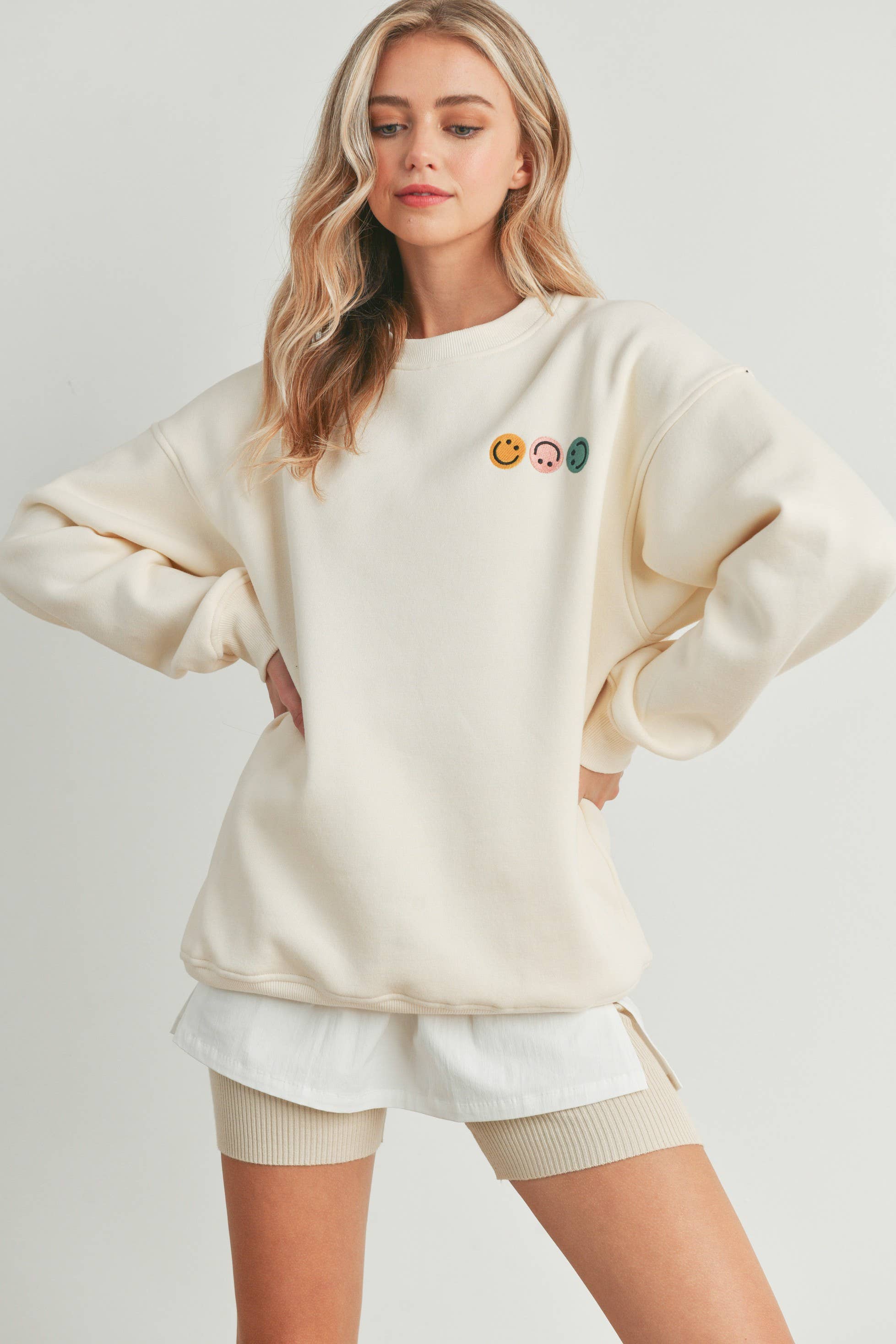 Smiley Face Embroidered Sweater with three smiley face details on the front and a larger smiley face on the back.