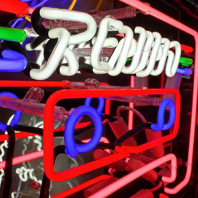 Vibrant Neon 'Cassette' Light in shades of blue, red, green, and pink, encased in a glossy acrylic box with a mirror back, making a striking retro statement.