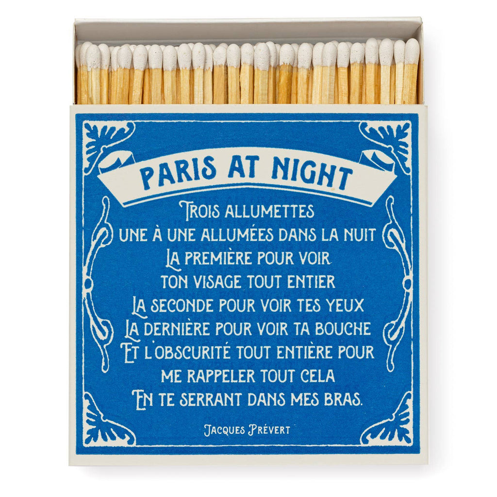 A square matchbox depicting the iconic sights of Paris illuminated at night.
