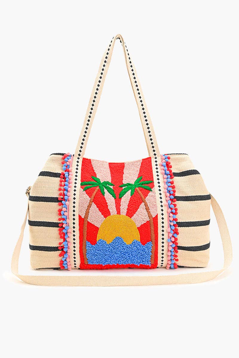 Beaded tote bag with sunset, palm tree, and ocean design, featuring black stripes, colorful pom-pom trim, and long handles.