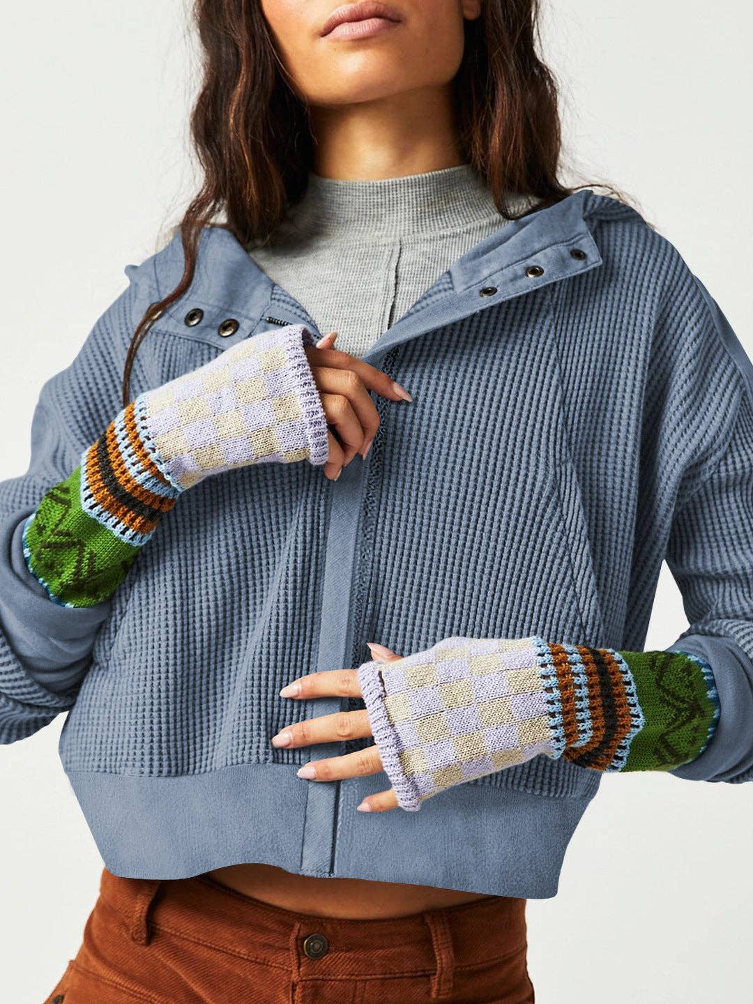 Woman wearing a Sahara Sky Hooded Jacket with a zip-up front, textured waffle knit, and button detailing in blue and brown tones.