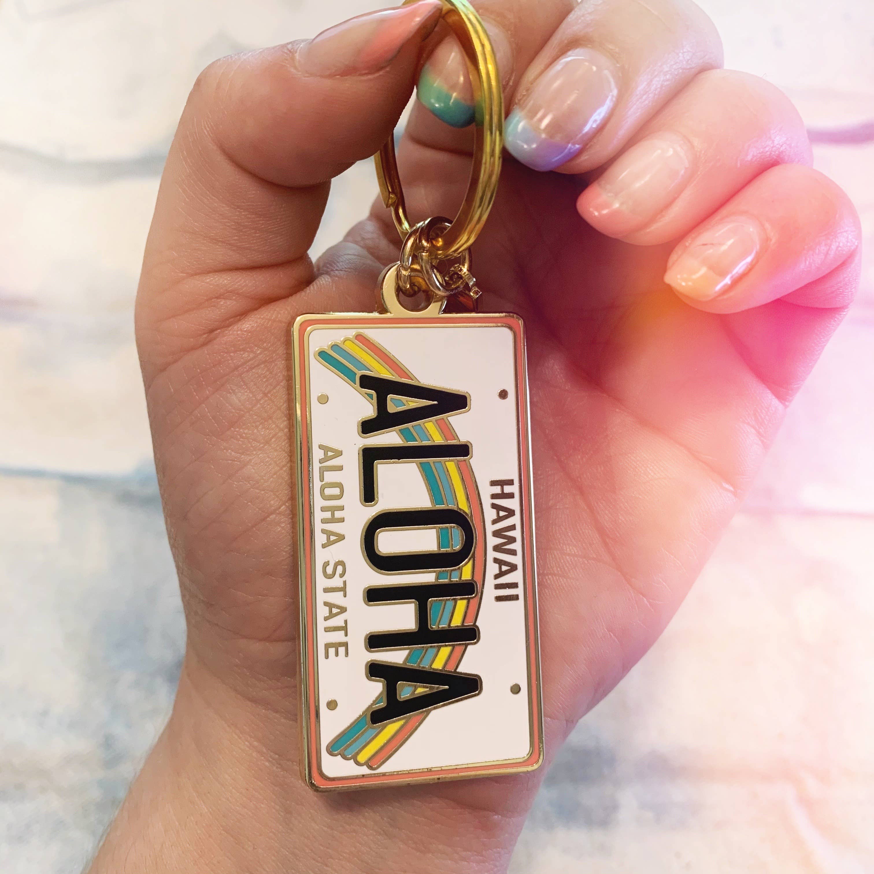 Aloha Enamel Keychain featuring a colorful rainbow and “Aloha” text.