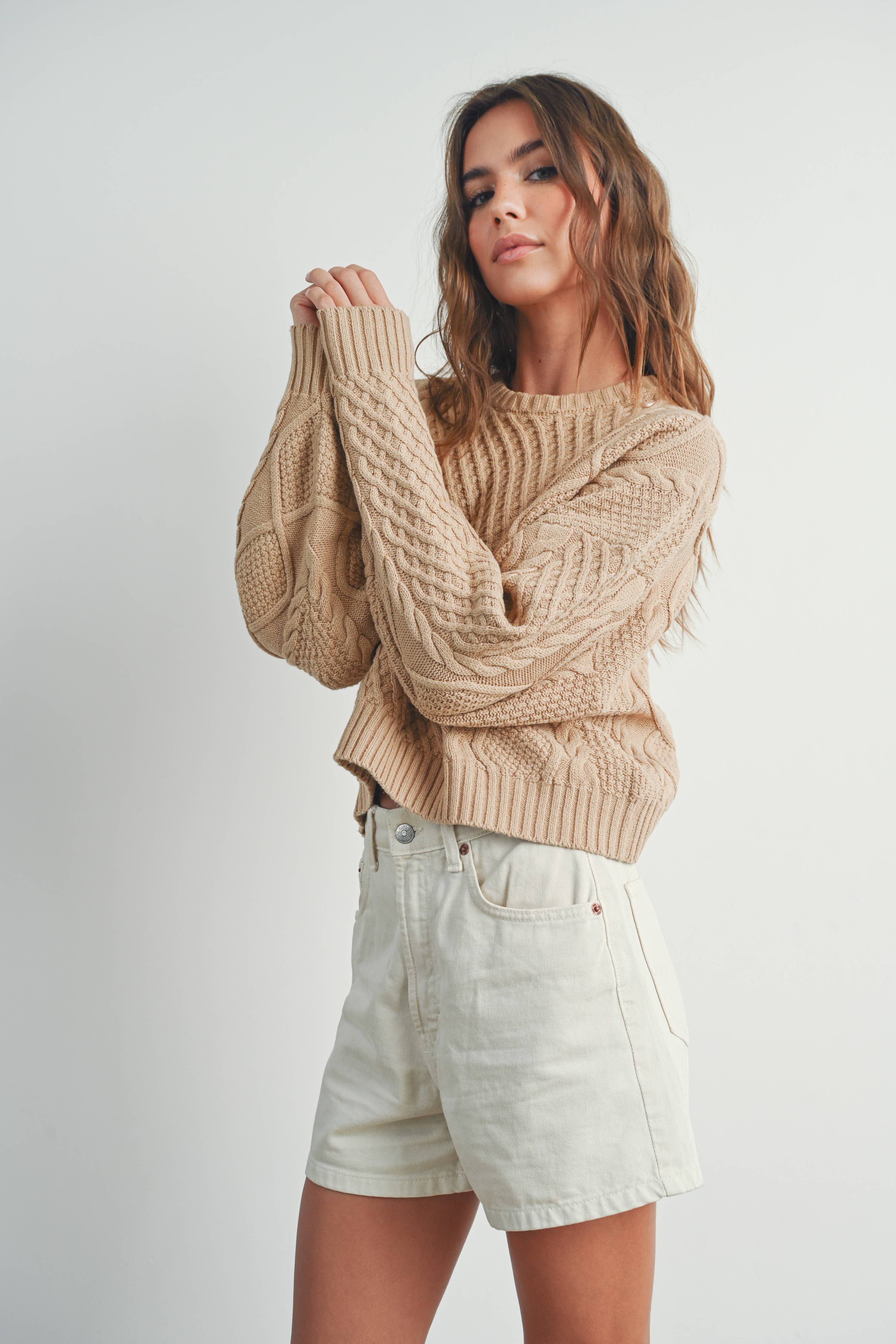 Sandridge Cable Knit Sweater with intricate cable detailing, relaxed fit, and warm beige hue, perfect for layering in any season.