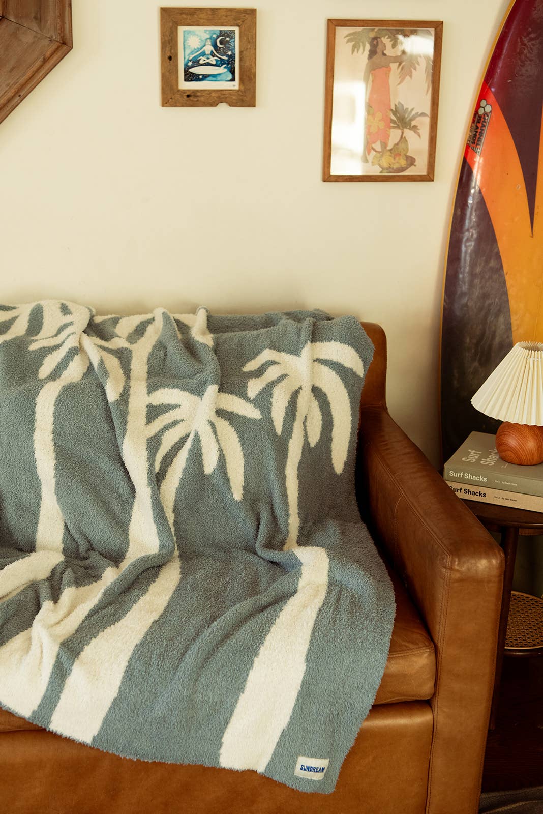 Soft chambray blue plush throw with palm tree design, perfect for cozying up or adding a beachy touch to any space.