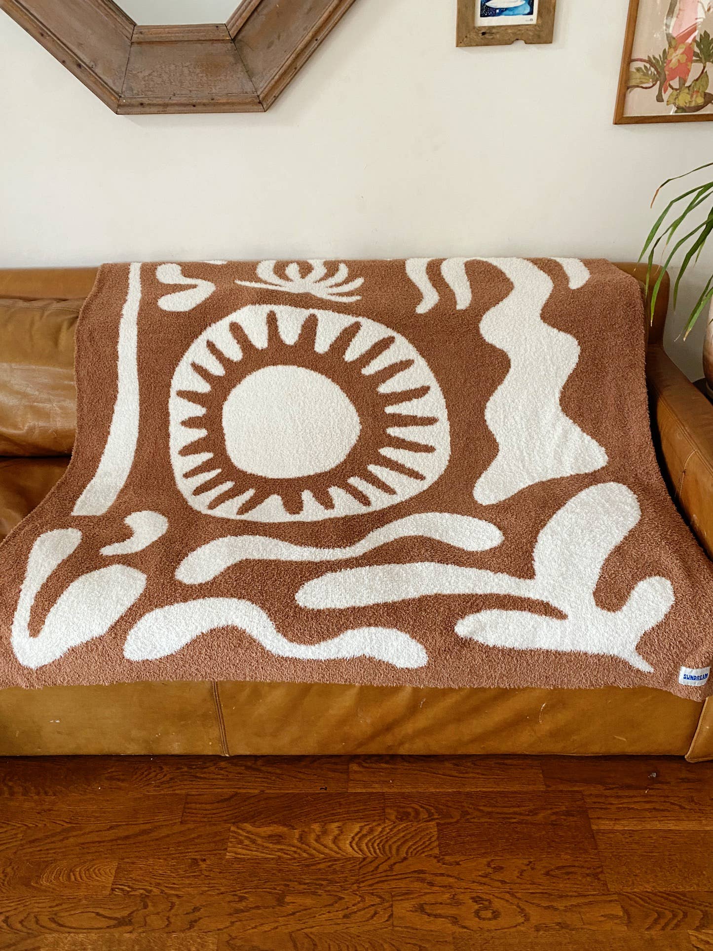 Soft brown plush throw blanket with a sun and palm tree design, perfect for adding warmth and a stylish accent to any space.