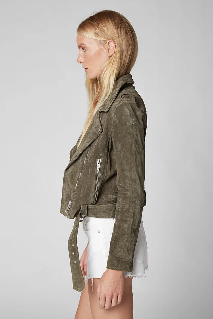 Woman wearing a green jacket on a gray background