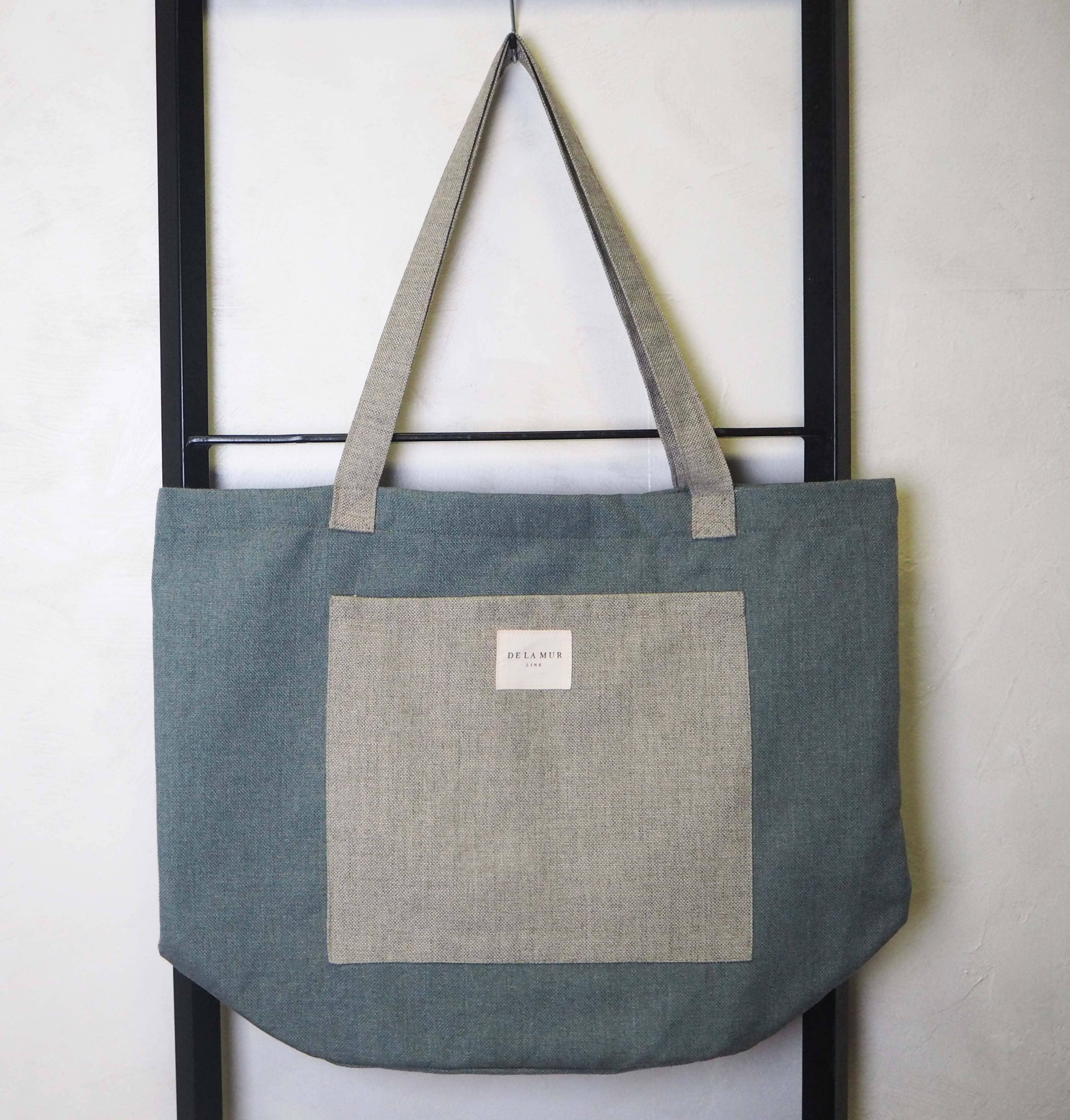 Mac Pocket Tote Large constructed from sturdy materials, exhibiting a minimalist design with substantial space