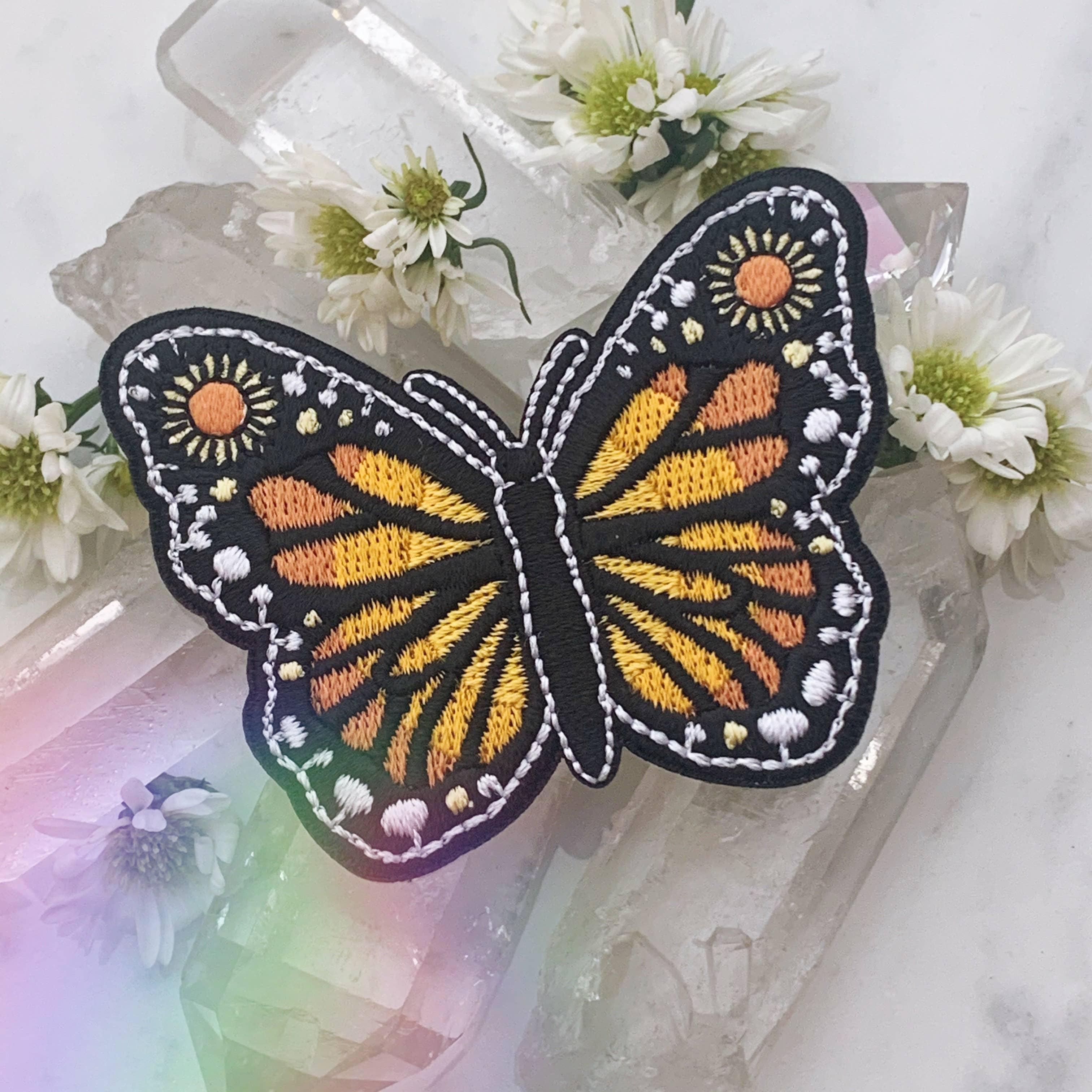 Vibrantly colored embroidered butterfly patch with detailed wing patterns.