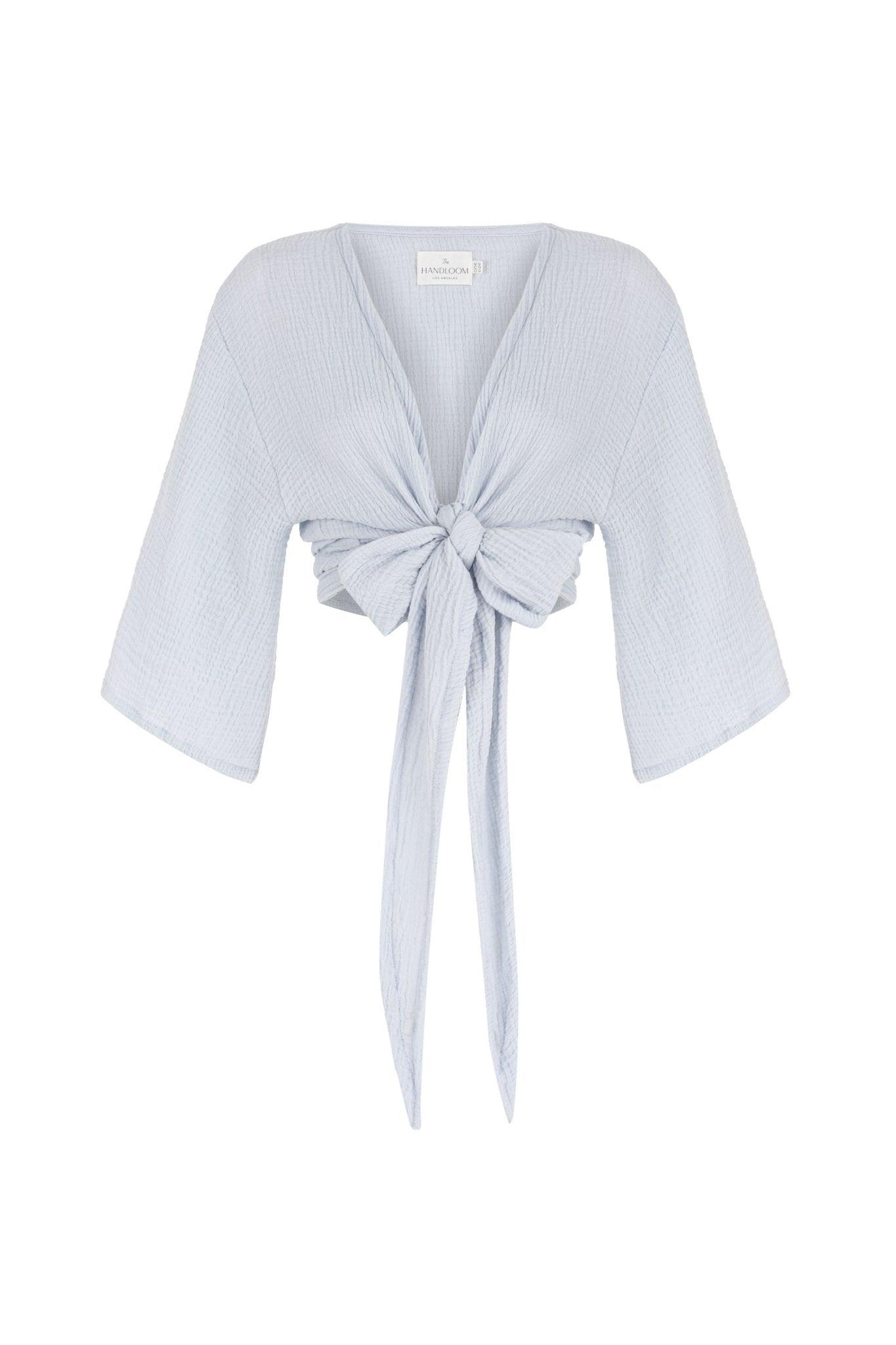 Stylish woman posing in a Bali Wrap Top with a V-neckline, front tie closure, and wide sleeves, highlighting its Turkish cotton fabric.