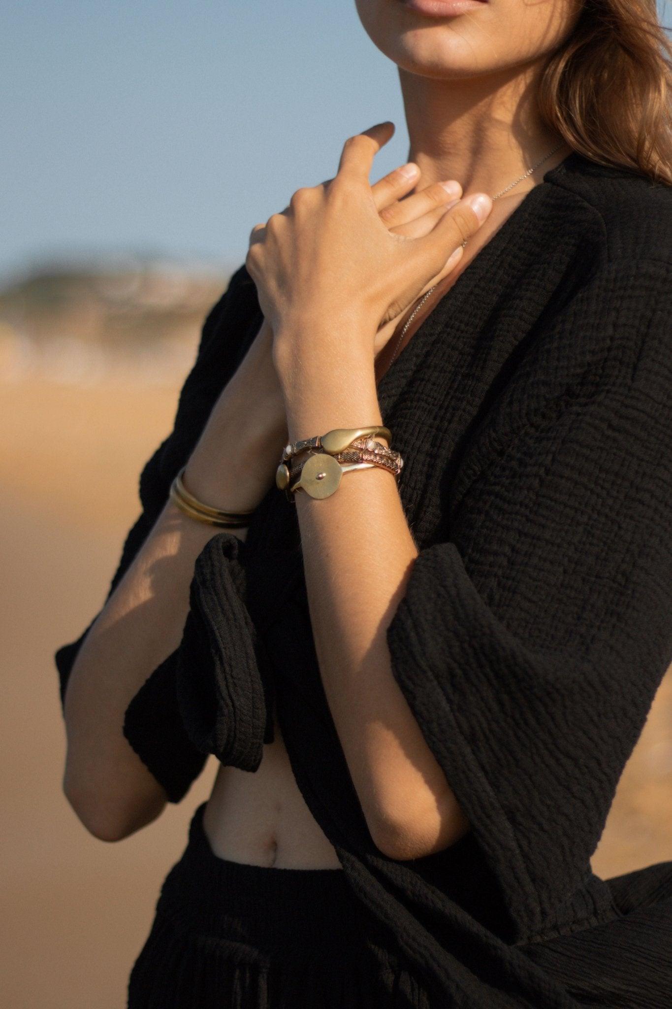 Stylish woman posing in a Bali Wrap Top with a V-neckline, front tie closure, and wide sleeves, highlighting its Turkish cotton fabric.