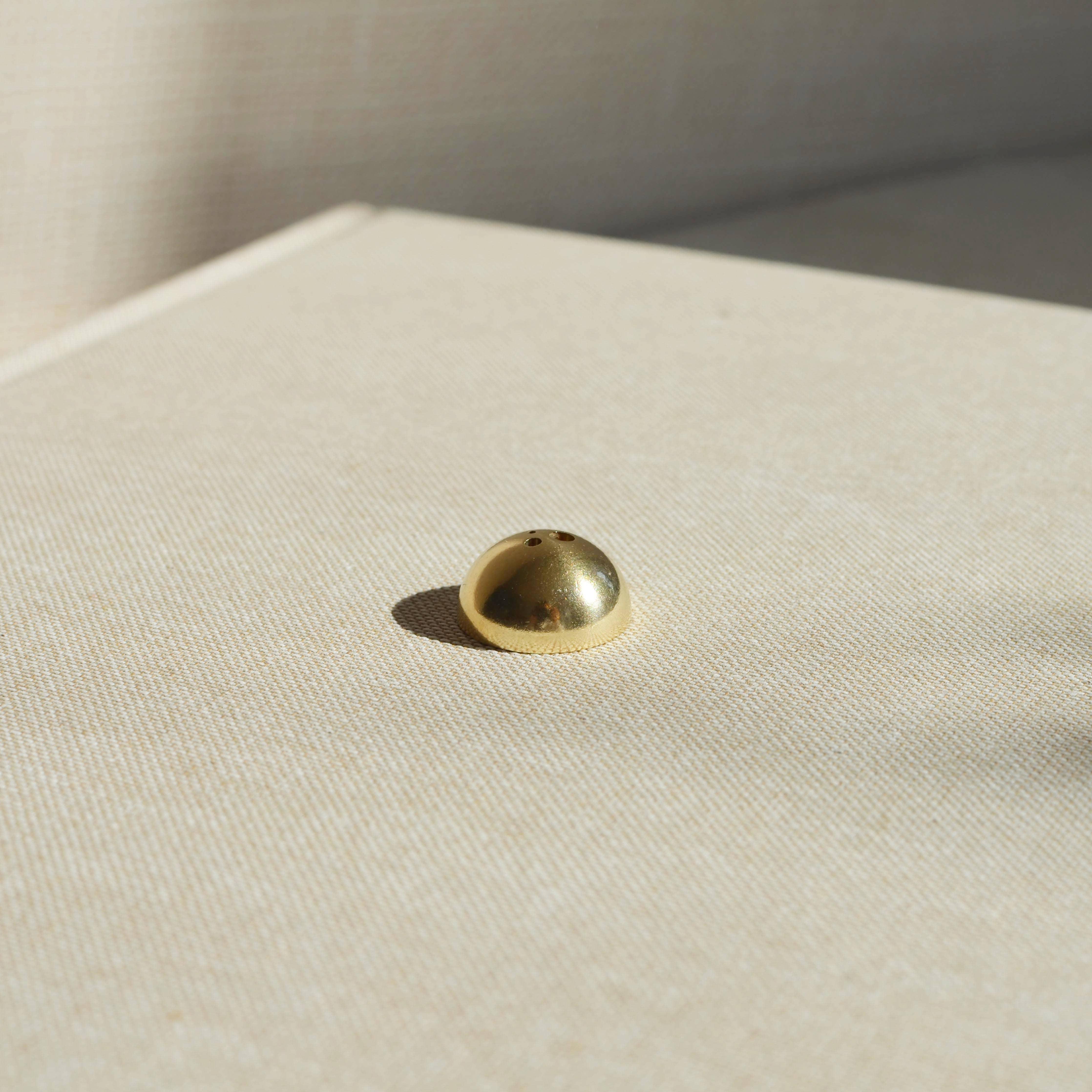 A stylish Brass Arch Incense Holder on a sleek backdrop, exuding modern elegance, designed to hold incense effortlessly.