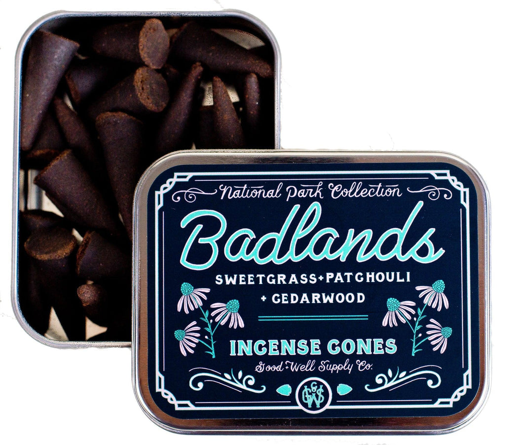 Package of Badlands Incense sticks against a backdrop depicting the wild and rugged terrain, symbolizing its earthy, resinous aroma.