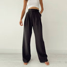 Woman wearing Urban Elegance Palazzo Pants in black color with a white crop top.