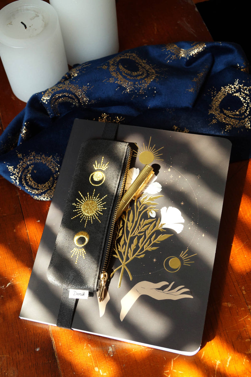 Moon Phase vegan leather pouch with gold embroidered moon phase design, zippered closure, and elastic band for notebooks.